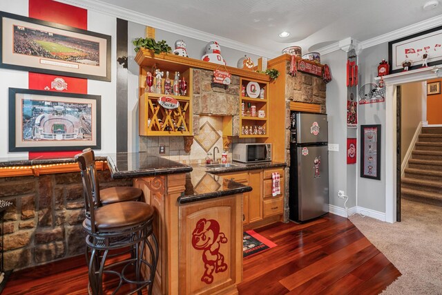 161 Calumet Ct, Ostrander, OH 43061 - indoor wet bar with stainless steel appliances, stairs, ornamental molding, dark wood-type flooring, and baseboards