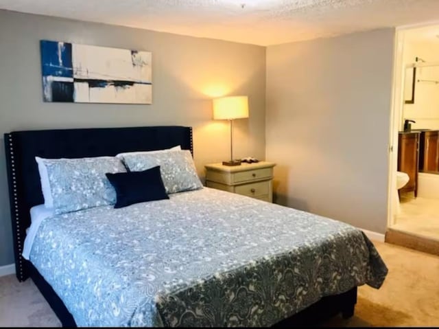 661 E 11th Ave, Columbus, OH 43211 - carpeted bedroom featuring baseboards and ensuite bathroom