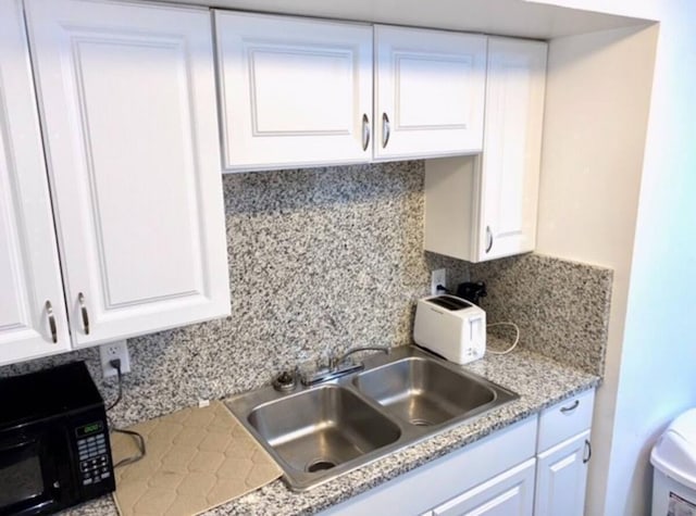 661 E 11th Ave, Columbus, OH 43211 - kitchen featuring black microwave, a sink, and white cabinetry