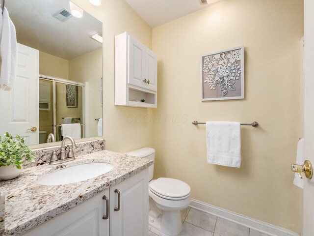 38 Ironclad Dr, Columbus, OH 43213 - bathroom with toilet, vanity, a stall shower, tile patterned floors, and baseboards