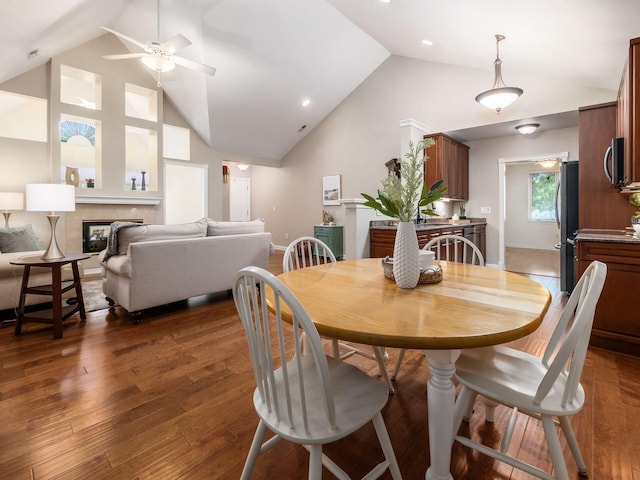 38 Ironclad Dr, Columbus, OH 43213 - dining area featuring a ceiling fan, wood finished floors, a tile fireplace, high vaulted ceiling, and baseboards