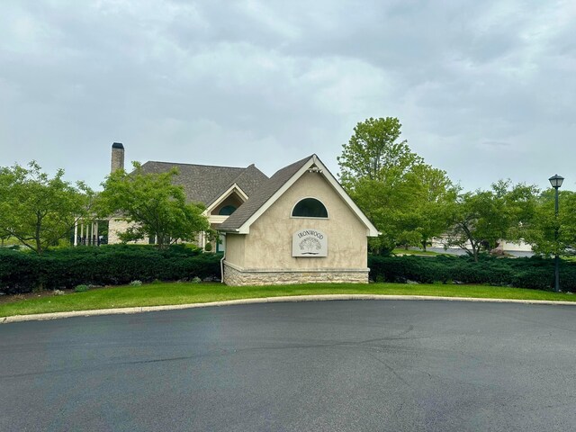 38 Ironclad Dr, Columbus, OH 43213 - view of side of property featuring stucco siding, a chimney, and stone siding