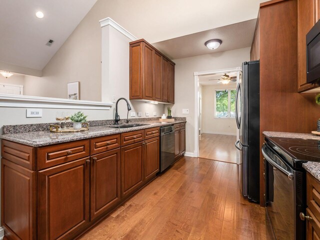 38 Ironclad Dr, Columbus, OH 43213 - kitchen featuring black appliances, a sink, light wood-type flooring, lofted ceiling, and light stone countertops
