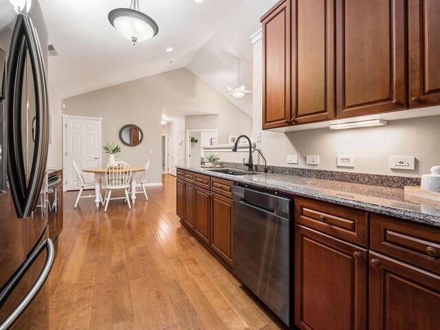 38 Ironclad Dr, Columbus, OH 43213 - kitchen with stainless steel appliances, a sink, vaulted ceiling, light wood-style floors, and dark stone counters