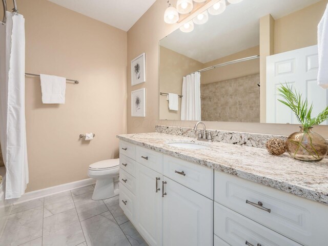 38 Ironclad Dr, Columbus, OH 43213 - full bathroom with vanity, toilet, marble look tile flooring, curtained shower, and baseboards