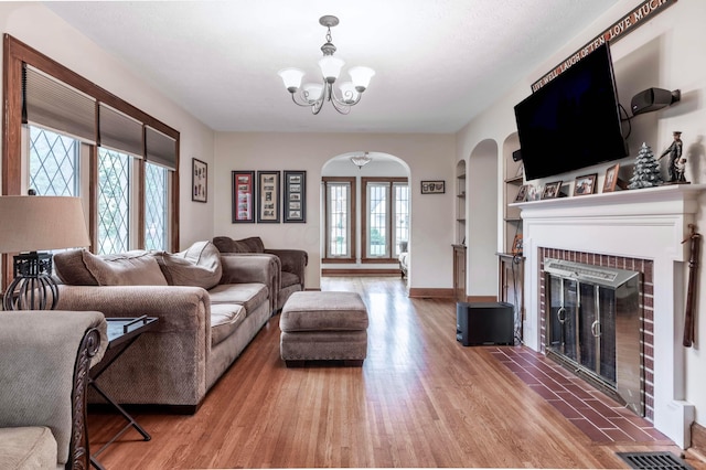750 E Allen St, Lancaster, OH 43130 - living area with arched walkways, healthy amount of natural light, a chandelier, and light wood-style floors