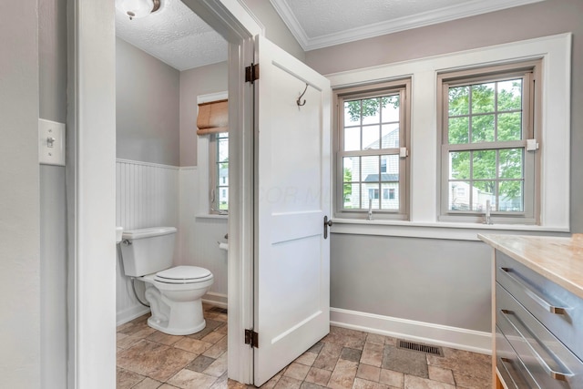 750 E Allen St, Lancaster, OH 43130 - bathroom featuring toilet, stone finish flooring, baseboards, a wainscoted wall, and a textured ceiling