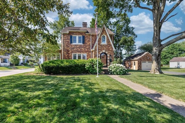 750 E Allen St, Lancaster, OH 43130 - tudor-style house with a chimney, brick siding, a front yard, and a garage