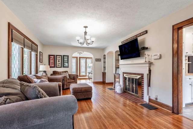750 E Allen St, Lancaster, OH 43130 - living room with arched walkways, plenty of natural light, a chandelier, light wood-type flooring, and a textured ceiling