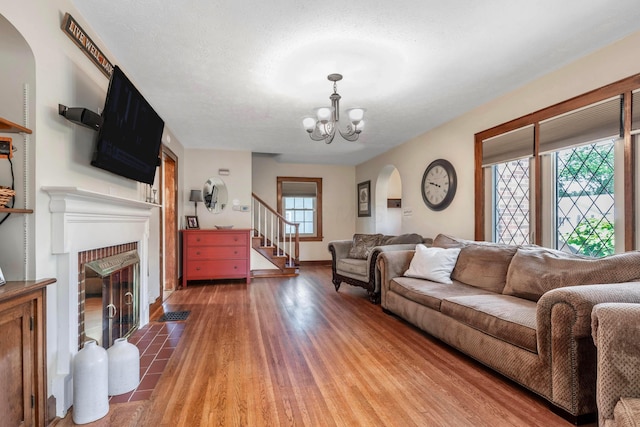 750 E Allen St, Lancaster, OH 43130 - living room with arched walkways, a fireplace, a chandelier, light wood-style floors, and stairway