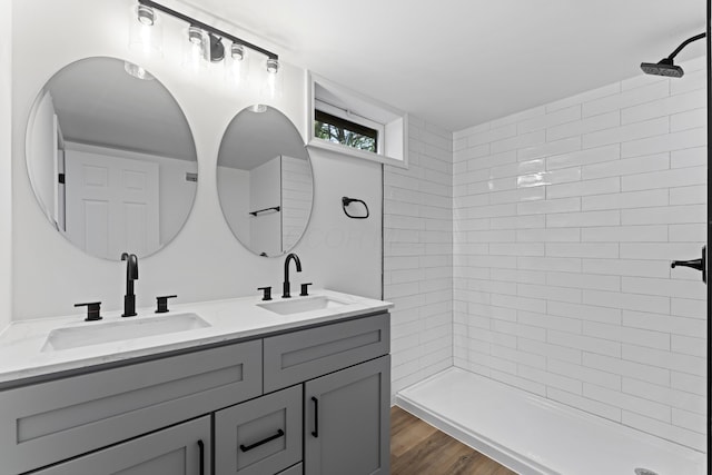 3129 Mcguffey Rd, Columbus, OH 43224 - full bath with double vanity, a tile shower, and wood finished floors