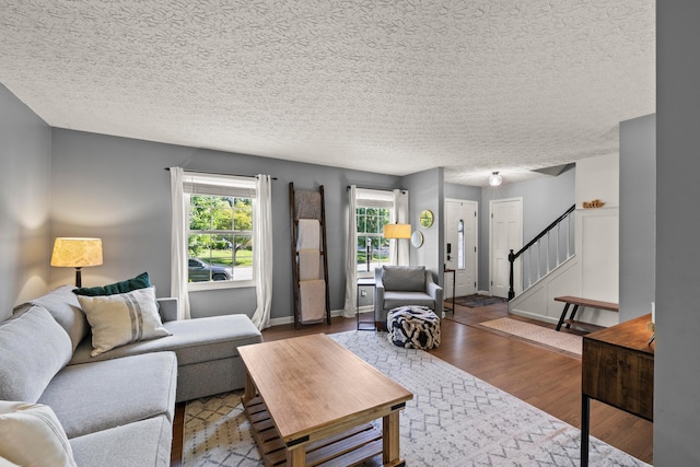 1997 Sutter Pkwy, Dublin, OH 43016 - living room with wood finished floors, stairs, a textured ceiling, and baseboards