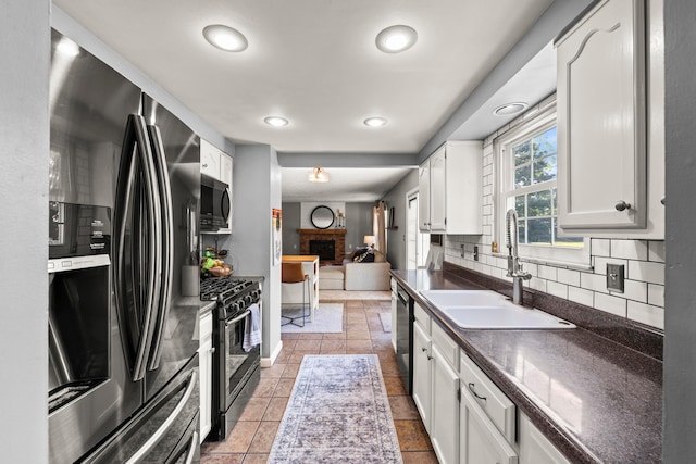 1997 Sutter Pkwy, Dublin, OH 43016 - kitchen featuring stainless steel appliances, a sink, dark countertops, backsplash, and white cabinets
