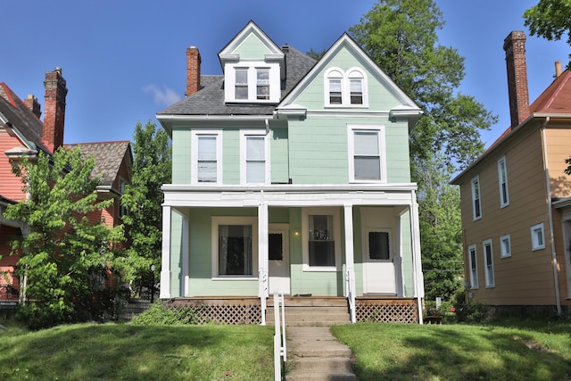 2045 N 4th St, Columbus, OH 43201 - victorian home featuring covered porch, a shingled roof, and a front lawn
