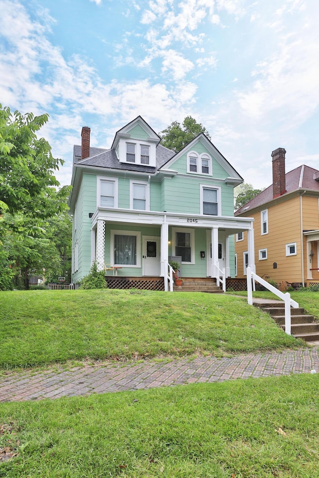 2045 N 4th St, Columbus, OH 43201 - view of front of property with covered porch, a front yard, and a chimney