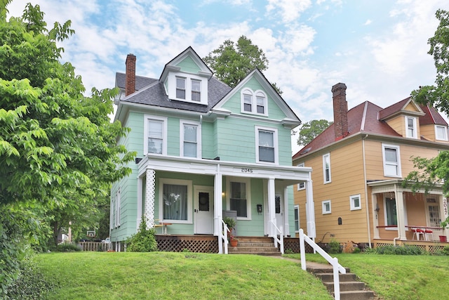 2045 N 4th St, Columbus, OH 43201 - view of front of home with covered porch, a chimney, and a front yard