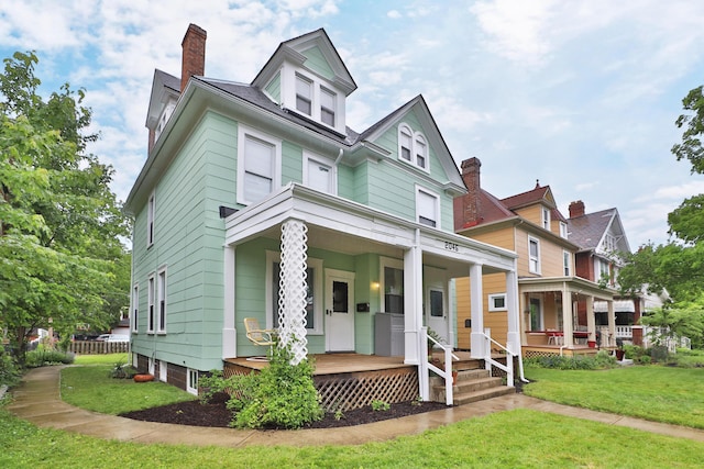 2045 N 4th St, Columbus, OH 43201 - view of front facade with covered porch, a front yard, and a chimney