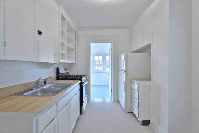 2045 N 4th St, Columbus, OH 43201 - kitchen with stainless steel range with gas cooktop, freestanding refrigerator, a sink, white cabinetry, and light countertops