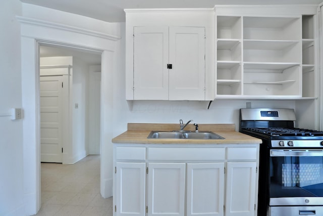 2045 N 4th St, Columbus, OH 43201 - kitchen with stainless steel gas range oven, a sink, white cabinetry, and light countertops