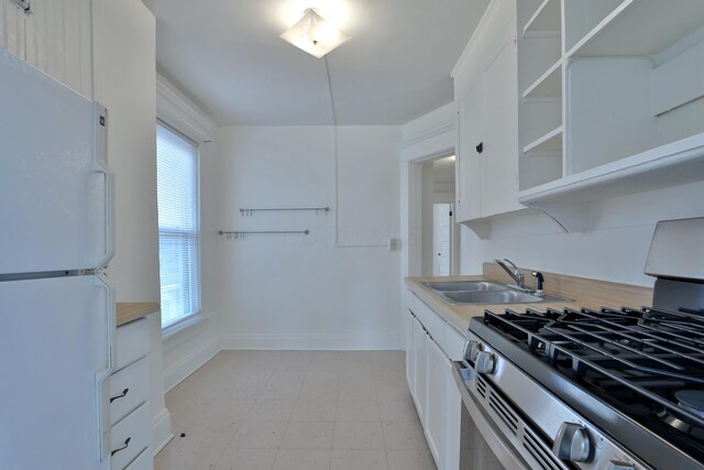 2045 N 4th St, Columbus, OH 43201 - kitchen with freestanding refrigerator, stainless steel gas range, a sink, and healthy amount of natural light