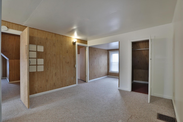 2045 N 4th St, Columbus, OH 43201 - unfurnished bedroom with carpet, wood walls, baseboards, and two closets