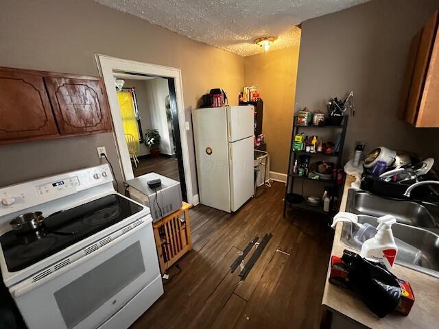1479 Genessee Ave, Columbus, OH 43211 - kitchen with white appliances, dark wood-type flooring, a textured ceiling, and brown cabinetry
