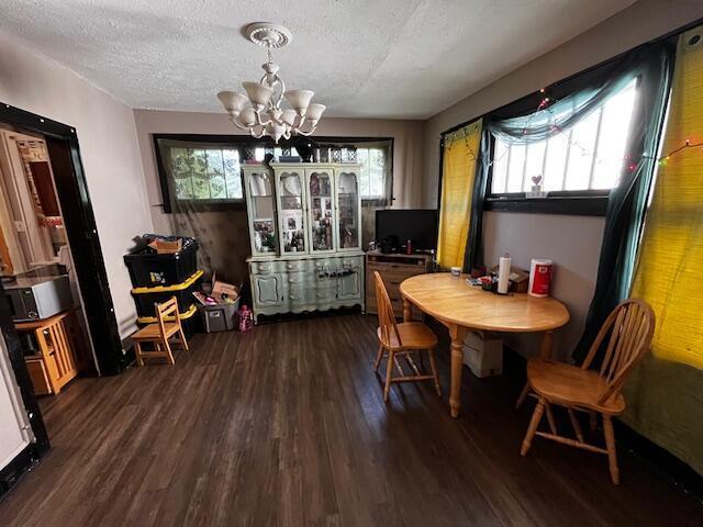 1479 Genessee Ave, Columbus, OH 43211 - dining area featuring a chandelier, dark wood-style floors, and a textured ceiling