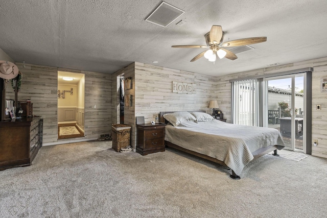21171 River Rd, Circleville, OH 43113 - bedroom featuring access to outside, a textured ceiling, carpet, wooden walls, and a ceiling fan