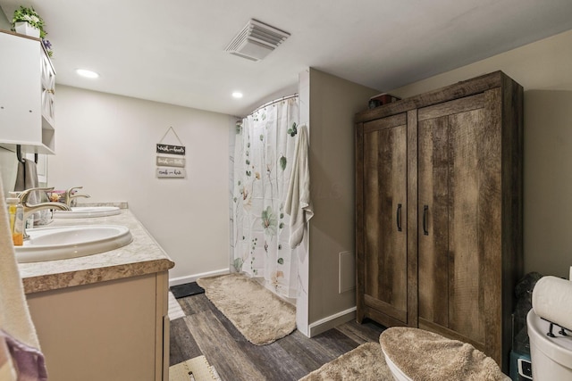 21171 River Rd, Circleville, OH 43113 - full bathroom featuring double vanity, wood finished floors, baseboards, recessed lighting, and curtained shower