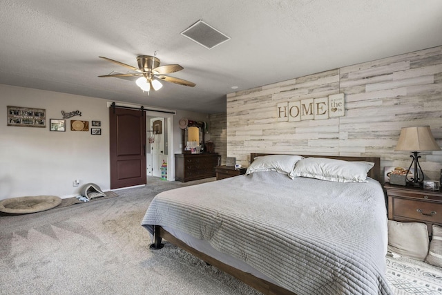 21171 River Rd, Circleville, OH 43113 - carpeted bedroom featuring a barn door, wood walls, a textured ceiling, and a ceiling fan