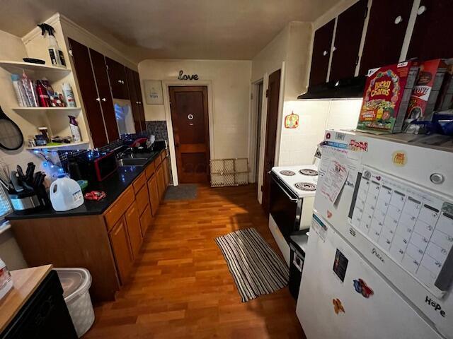 2428 Bancroft St, Columbus, OH 43211 - kitchen with light wood-style floors, a sink, electric range, dark countertops, and brown cabinets