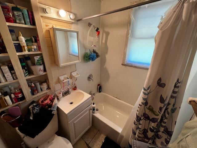 2428 Bancroft St, Columbus, OH 43211 - full bath featuring shower / bath combination with curtain, vanity, toilet, decorative backsplash, and tile patterned floors