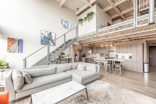 367 Auden Ave Unit 306, Columbus, OH 43215 - living area featuring a towering ceiling, stairs, and light wood-style floors