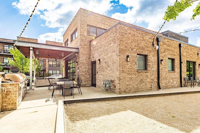 367 Auden Ave Unit 306, Columbus, OH 43215 - rear view of property with a patio area, brick siding, and exterior kitchen
