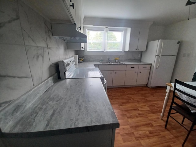 4891 Marion Mount Gilead Rd, Caledonia, OH 43314 - kitchen with freestanding refrigerator, wall chimney range hood, a sink, stove, and wood finished floors