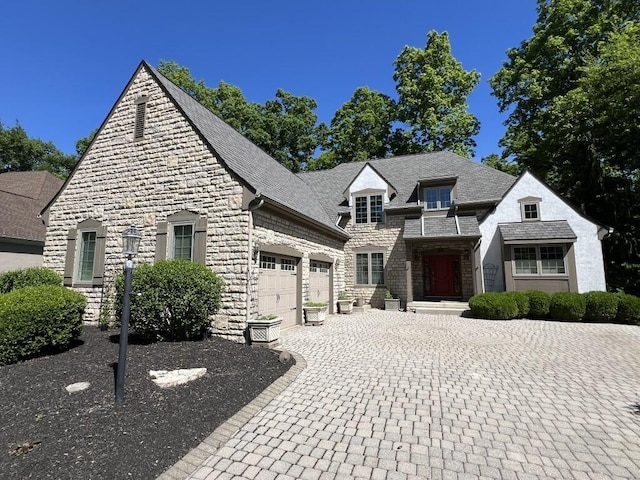 5645 Travis Pointe Ct, Westerville, OH 43082 - french country inspired facade featuring stone siding, an attached garage, and decorative driveway