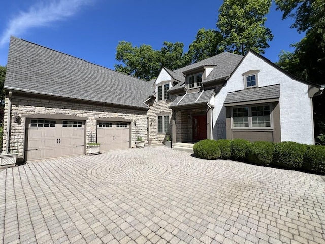 5645 Travis Pointe Ct, Westerville, OH 43082 - view of front facade with decorative driveway, stone siding, a garage, and stucco siding