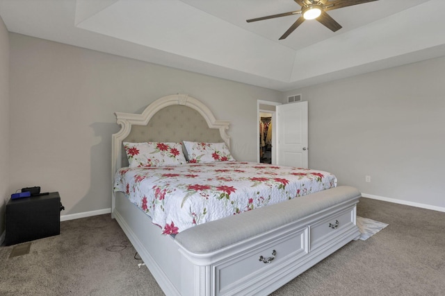 7142 Duke Dr, Canal Winchester, OH 43110 - carpeted bedroom with a tray ceiling, baseboards, ceiling fan, and a walk in closet