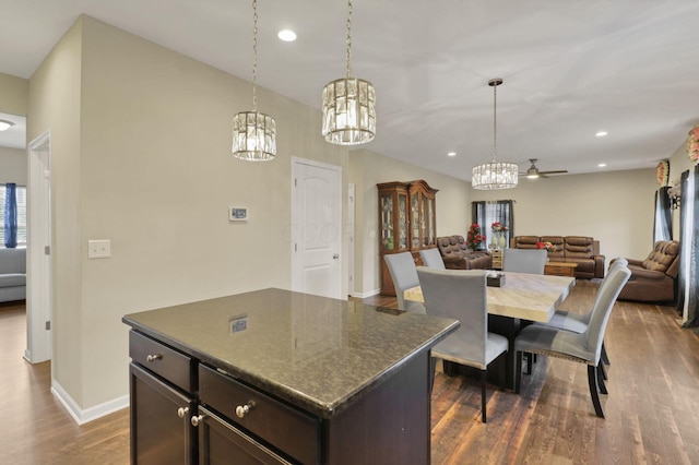 7142 Duke Dr, Canal Winchester, OH 43110 - kitchen featuring a chandelier, a kitchen island, dark wood-type flooring, open floor plan, and baseboards