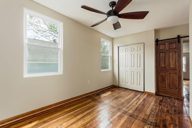 471 Southwood Ave, Columbus, OH 43207 - unfurnished bedroom featuring hardwood / wood-style floors, multiple windows, a closet, and baseboards