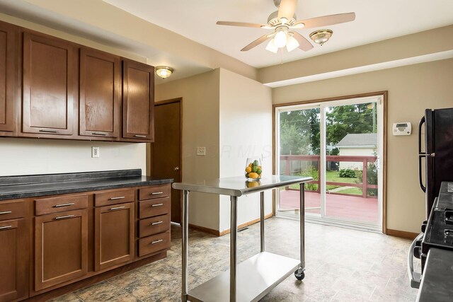 471 Southwood Ave, Columbus, OH 43207 - kitchen featuring freestanding refrigerator, a ceiling fan, dark countertops, baseboards, and stone finish floors