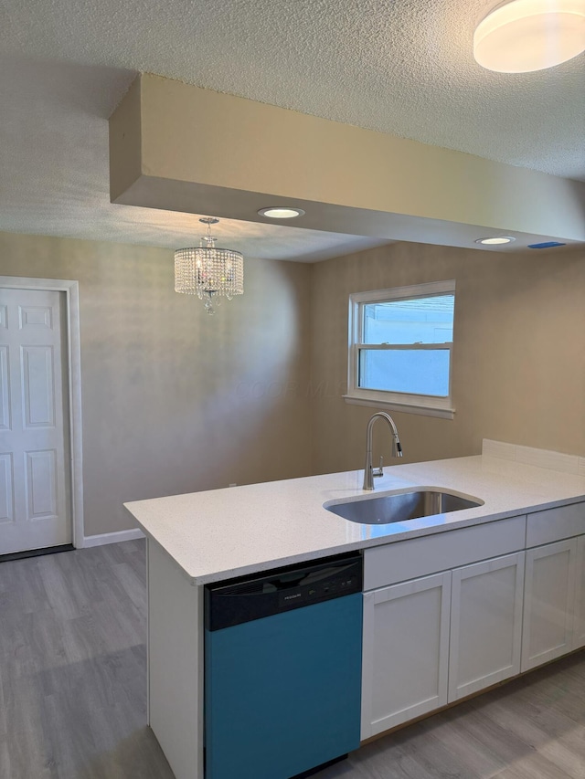 5123 Jameson Dr, Columbus, OH 43232 - kitchen featuring dishwashing machine, a sink, wood finished floors, a textured ceiling, and light countertops