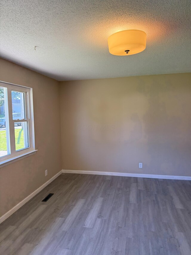 5123 Jameson Dr, Columbus, OH 43232 - empty room with wood finished floors, a textured ceiling, and baseboards