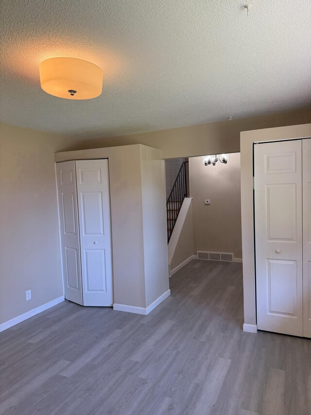 5123 Jameson Dr, Columbus, OH 43232 - empty room featuring a textured ceiling, wood finished floors, baseboards, and stairway