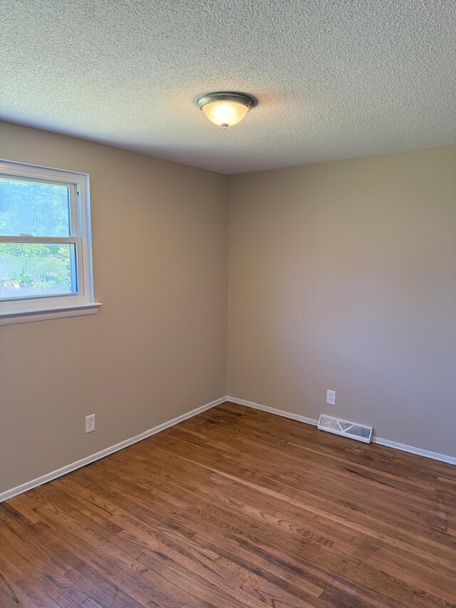 5123 Jameson Dr, Columbus, OH 43232 - unfurnished room with dark wood-style flooring, baseboards, and a textured ceiling