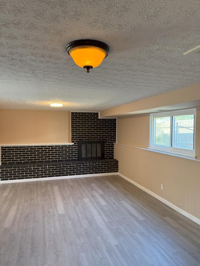 5123 Jameson Dr, Columbus, OH 43232 - unfurnished living room with wood finished floors, a textured ceiling, a fireplace, and baseboards