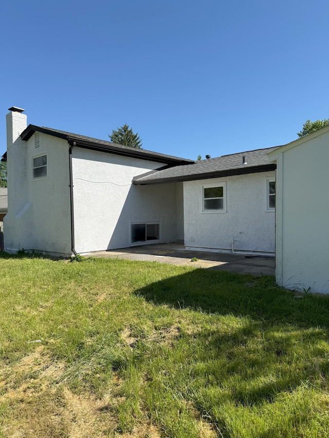 5123 Jameson Dr, Columbus, OH 43232 - rear view of property featuring a lawn, stucco siding, and a chimney