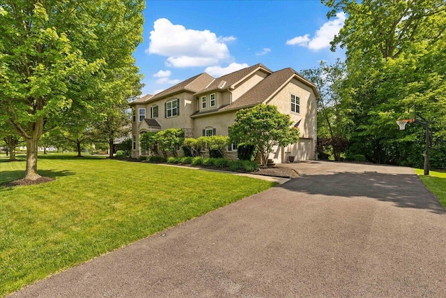 3144 Abbey Knoll Dr, Lewis Center, OH 43035 - traditional-style house featuring stucco siding, asphalt driveway, an attached garage, and a front lawn