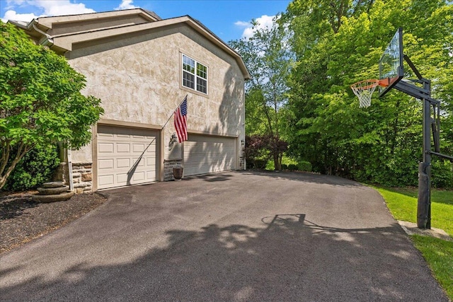3144 Abbey Knoll Dr, Lewis Center, OH 43035 - view of home's exterior featuring stucco siding, asphalt driveway, stone siding, and a garage
