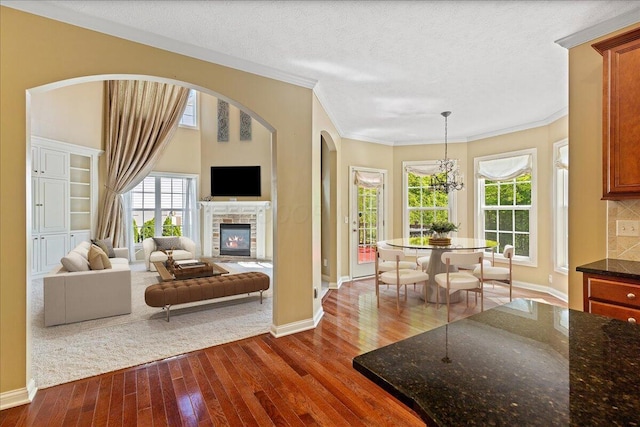 3144 Abbey Knoll Dr, Lewis Center, OH 43035 - living room with dark wood-type flooring, baseboards, crown molding, and a stone fireplace